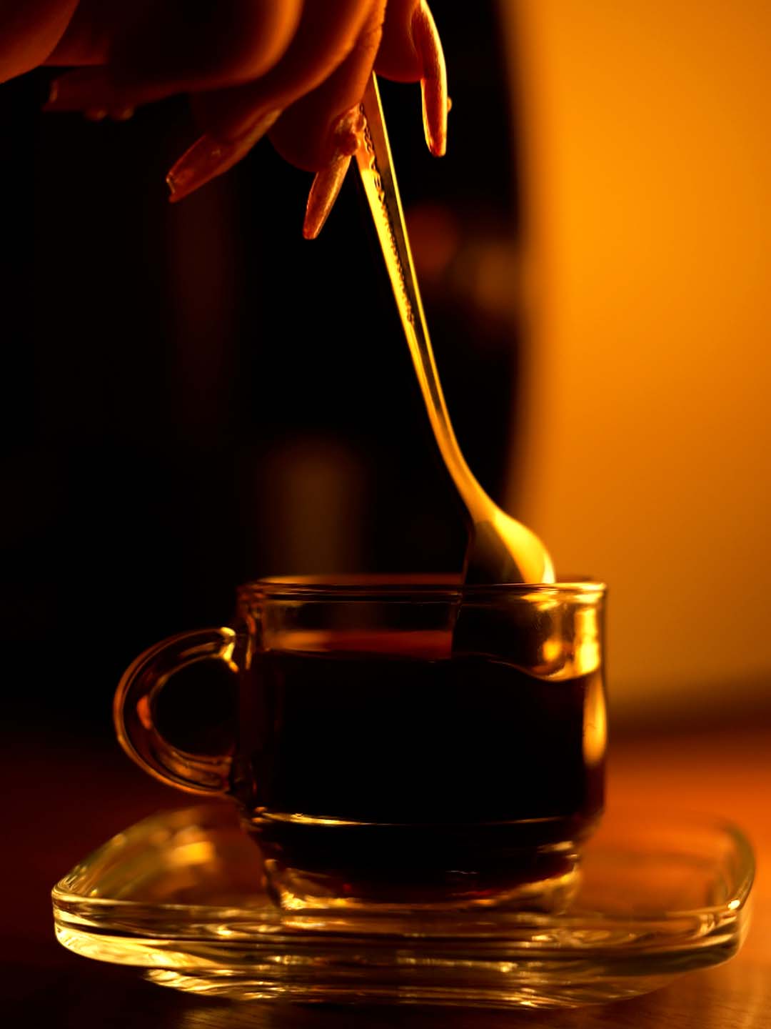 Main qui tiens une cuillère qui touille le café