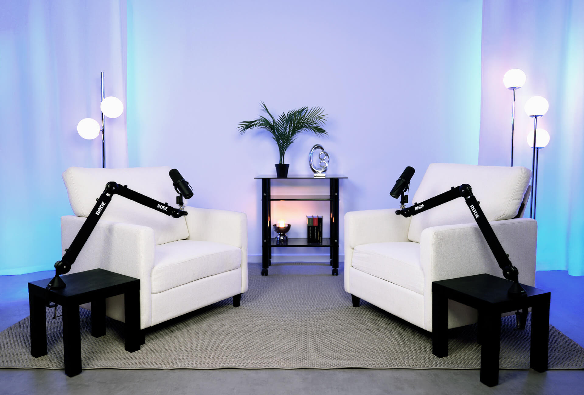 Photo du décor blanc de notre studio vidéo avec 2 fauteuils blancs et des projections de lumières bleues 
