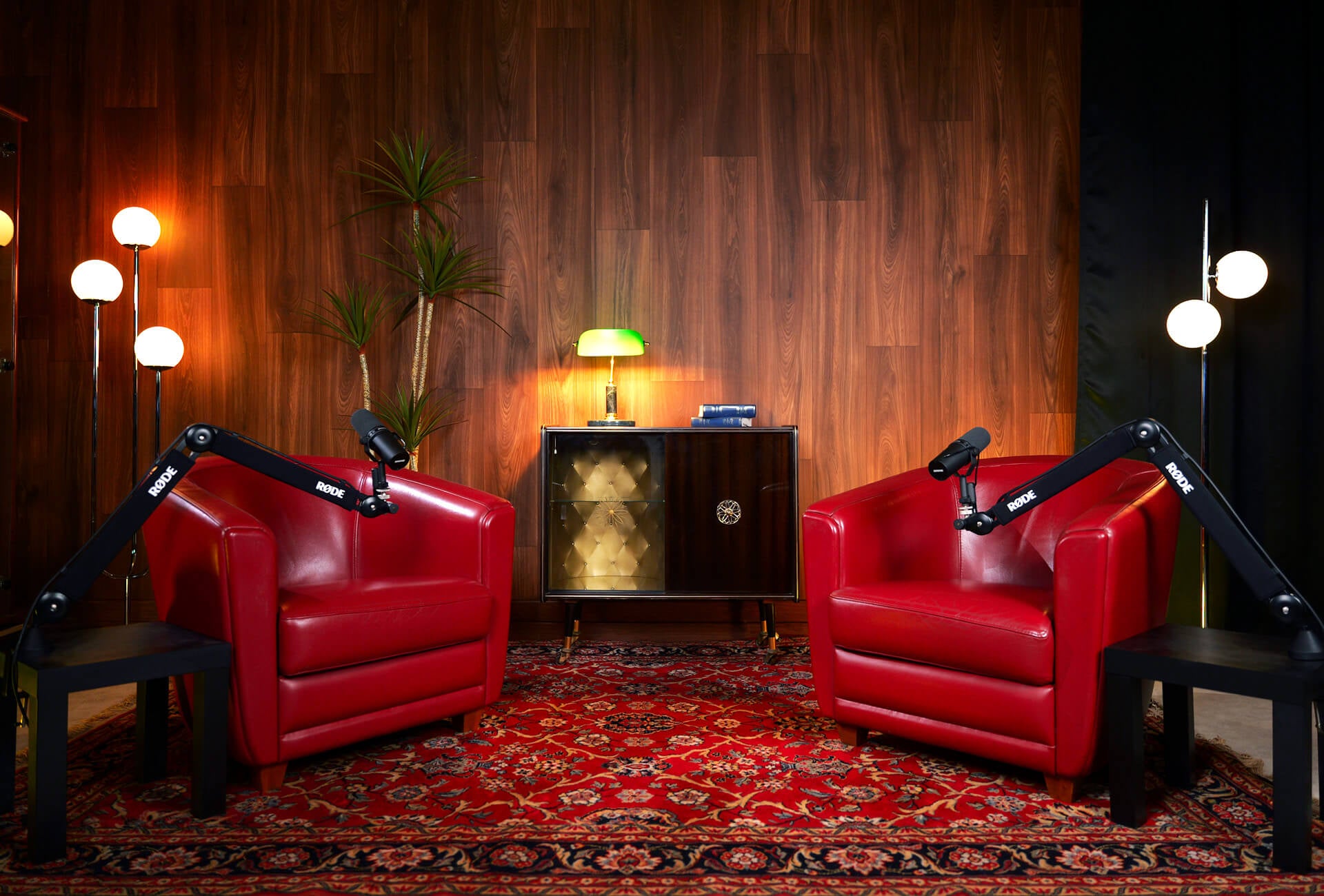 Photo du décor lounge avec le fond en bois et les fauteuils rouge de notre studio de podcast à Toulouse