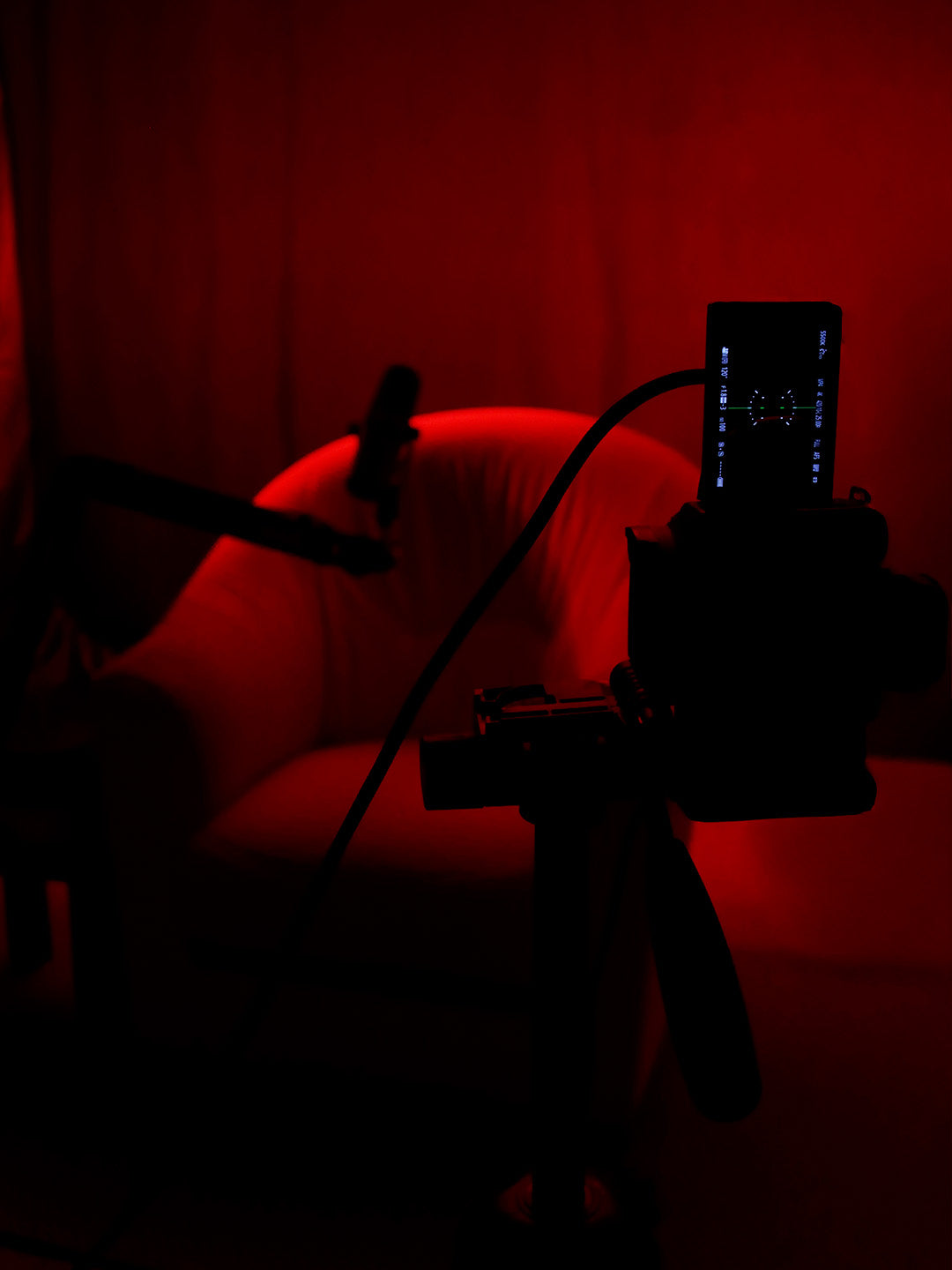 Caméra en premier plan et arrière plan avec un décor de podcast sombre et rouge