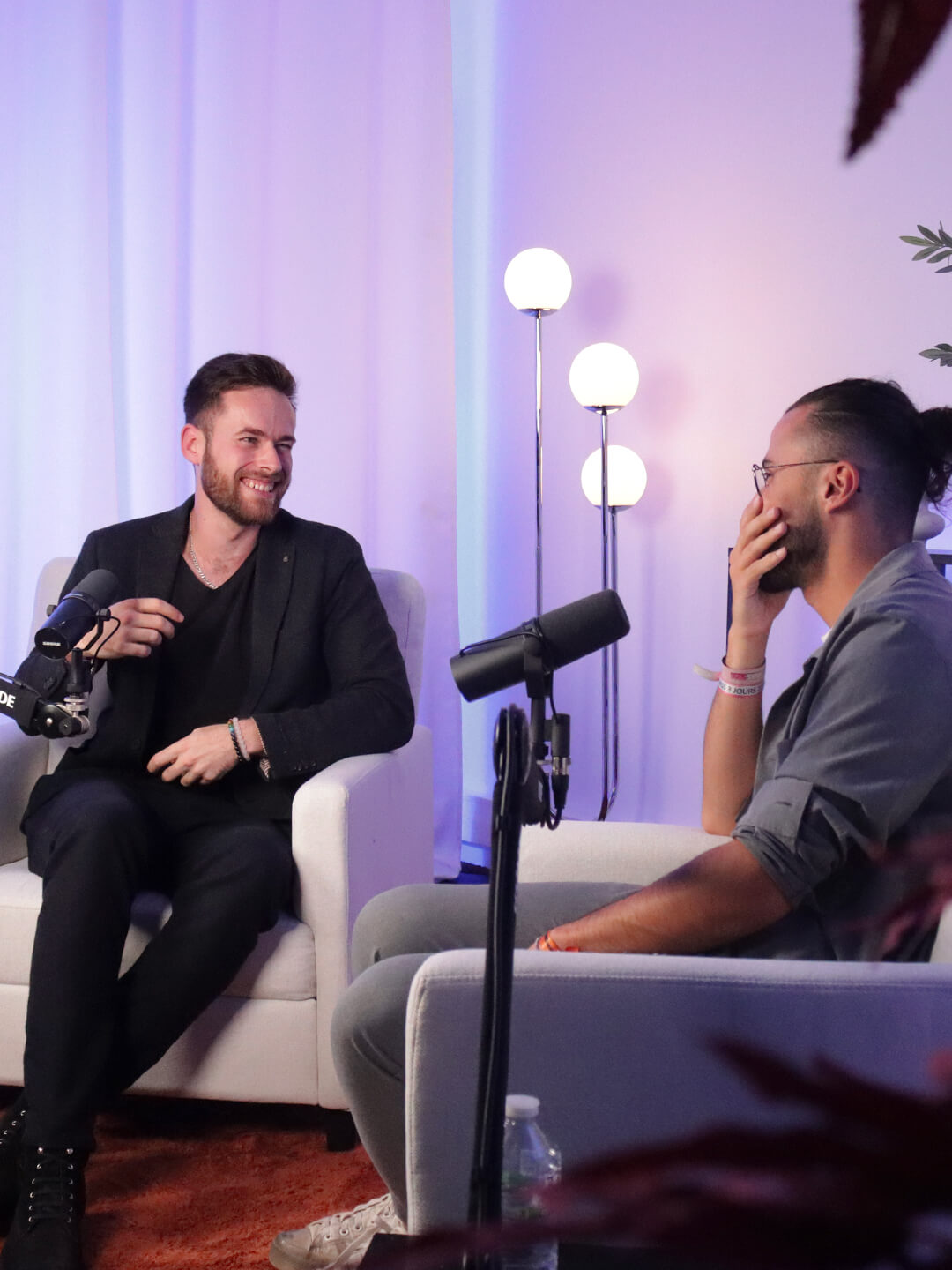 2 garçons qui rigoles lors d'un interview vidéo, dans un décor bleu