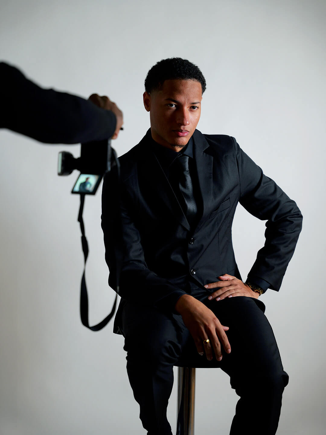 Homme assis sur un tabouret en train d'être shooté par un photographe