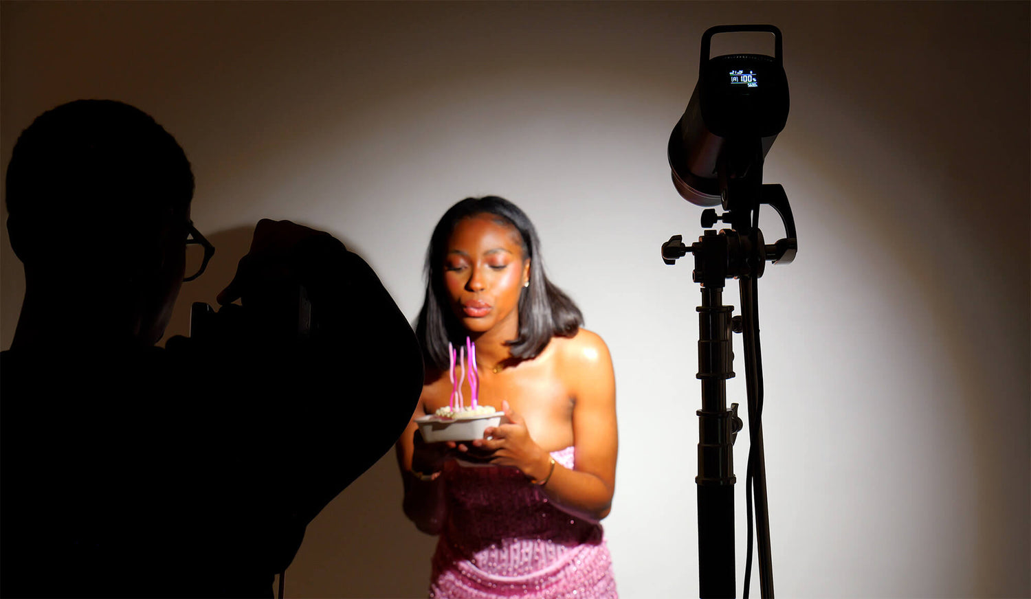 Shooting photo d'une fille qui souffle des bougies sur son gâteau d'anniversaire